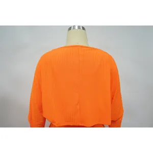 Detaillierte Rückansicht eines hellorangefarbenen, gerippten langärmeligen Damen-Capes