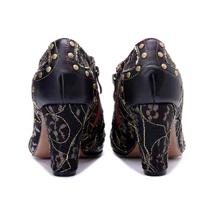 Detailed rear view of handcrafted retro leather high-heeled boots with bronze rivets