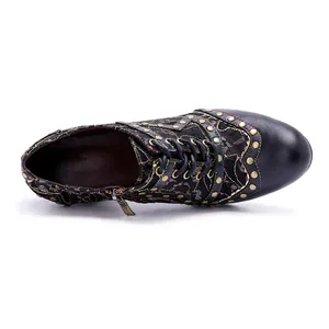 Detailed top view of vintage handmade leather high heels with rivets and embroidery