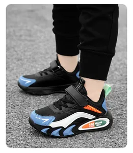 Detailansicht von Jungen-Sportschuhen mit blauen und orangen Akzenten auf grauem Boden.