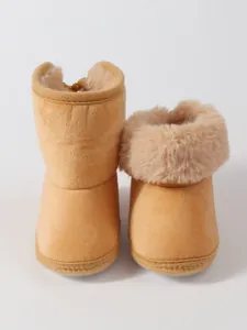 Detailed view of soft tan baby snow boots with fluffy faux fur lining for winter