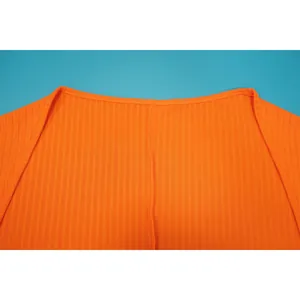 Makroansicht des orangefarbenen Rippenstoff-Ausschnitts mit feinen Nahtdetails