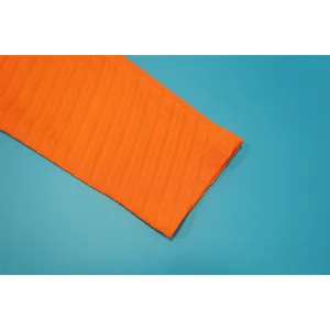 Nahaufnahme des orangefarbenen gerippten Ärmels mit feiner Textur und sauberen Nähten