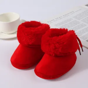 Detailed view of red fuzzy baby winter boots with soft soles for infants and toddlers
