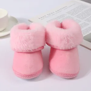 Detail view of soft pink plush baby winter boots featuring fluffy faux fur trim around ankle