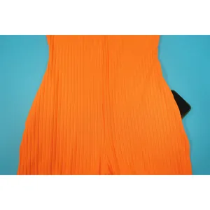 Detailansicht einer funktionalen Seitentasche auf orangefarbenem Rippstoff-Jumpsuit.