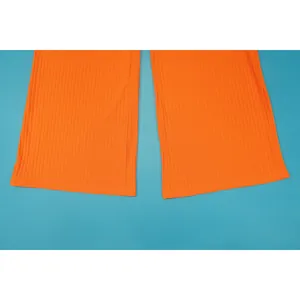 Nahaufnahme der leuchtend orangefarbenen, gerippten Weitbeinhosenbündchen auf blau
