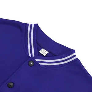 Détail du col d'une veste de baseball bleue avec bord-côte rayé et étiquette de taille