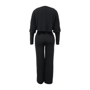 Detaillierte Rückansicht eines schicken schwarzen Jumpsuit-Sets mit Langarm-Cape-Top