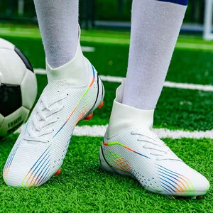 Detailansicht von weißen High-Top-Fußballschuhen mit bunten Streifen auf grünem Rasen