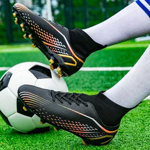 Professionelle schwarze High-Top-Fußballschuhe mit orangem Muster auf Rasen.