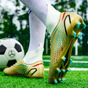 Detailaufnahme goldener High-Top-Fußballschuhe mit türkisen Stollen auf grünem Rasen