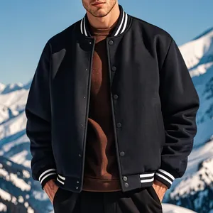 Détail d'un blouson teddy rétro bleu marine avec bords rayés dans un décor de montagnes enneigées
