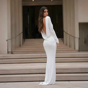 Back view of an elegant white backless maxi dress with long sleeves on a model