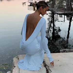 Detailed view of an elegant white backless maxi dress with long sleeves and slim fit.
