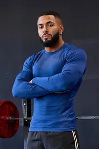 Detailed view of blue men's slim fit long-sleeve sports training shirt on fitness model