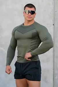 Muscular man wearing a slim fit olive green long sleeve athletic t-shirt for fitness training.