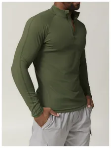 Vue latérale d'un t-shirt de sport olive à quart de zip montrant la coupe et le tissu.