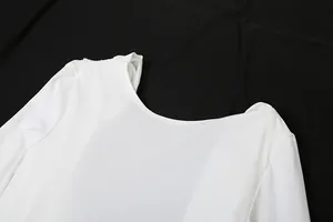 Gros plan d'une élégante robe de soirée blanche à manches longues, col dégagé.