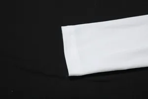 Gros plan sur le poignet de manche blanc et les doubles surpiqûres d'une robe élégante