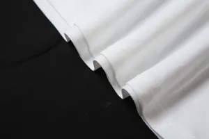 Vue détaillée montrant le tissu blanc de haute qualité et la couture de l'ourlet de la robe