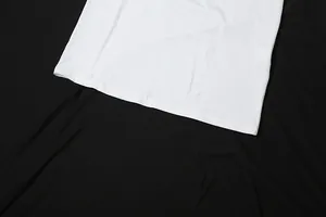 Vue détaillée de l'ourlet de la robe de soirée blanche, montrant la couture de qualité