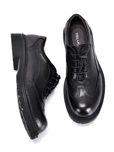Vista dettagliata delle scarpe Derby da uomo in pelle nera con suole spesse e stringate