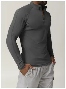 Détail rapproché d'un t-shirt de sport à manches longues gris foncé avec zip pour homme fitness
