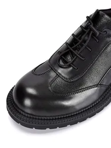 Dettaglio ravvicinato delle scarpe Derby nere in pelle bovina con suola spessa