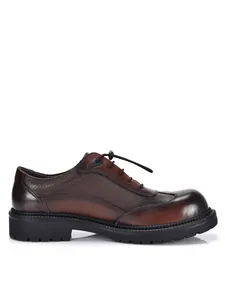 Dettaglio laterale di scarpe derby da uomo in pelle marrone con suola spessa robusta.