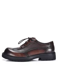 Vista laterale di scarpe Derby in pelle lucida marrone con spesse suole in gomma nera.