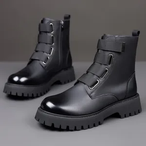 Close-up of black leather Martin boots with decorative straps and thick lug sole.
