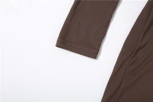 Macro detail showing the long sleeve cuff with double-needle stitching on brown dress