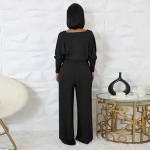 Rückansicht eines schwarzen gerippten langärmeligen Jumpsuits in eleganter Umgebung