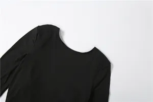 Close-up detail of the sexy backless neckline on an elegant black slim long-sleeved maxi dress.