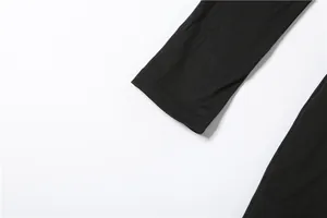 Close-up detail of a black long-sleeved dress cuff showing fine stitching and fabric texture.