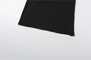 Close-up detail of the smooth black dress hemline and high-quality stitching work