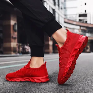 Sneakers fly-knit rosso vibrante per uomo e donna in un contesto urbano moderno.