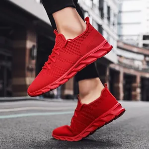 Dettaglio ravvicinato di scarpe da ginnastica in maglia rosso acceso indossate per strada