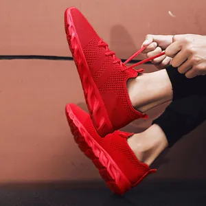 Primo piano di scarpe da ginnastica in mesh rosso allacciate su sfondo strutturato