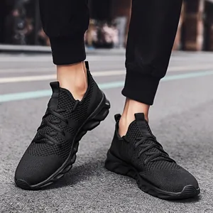 Dettaglio scarpe da ginnastica flyknit nere con tomaia in mesh e suola a onde spessa
