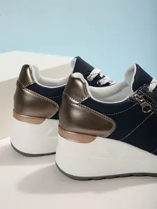Λεπτομερής όψη γυναικείων sneakers με πλατφόρμα σε μπλε σκούρο και χάλκινες λεπτομέρειες