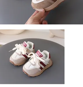 Close-up detail of toddler sneakers featuring beige and burgundy colors with non-slip sole