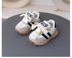Close-up of children's retro sneakers with non-slip soft soles in beige and white