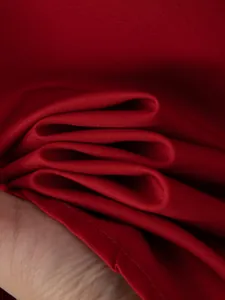 Primo piano del tessuto elasticizzato in quattro direzioni rosso scuro con cuciture.