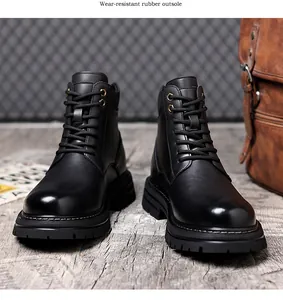 Vue de face de deux bottines Martin en cuir noir sur un sol rustique en bois clair