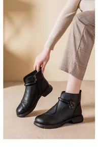 Close-up of black winter ankle boots for women with side flower detail and zipper