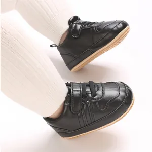 Primo piano di scarpe sportive nere per neonati con suola morbida indossate da un bambino
