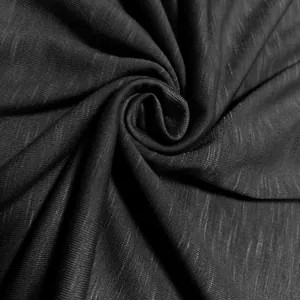 Macro close-up showing the textured black slub jersey fabric for men's apparel