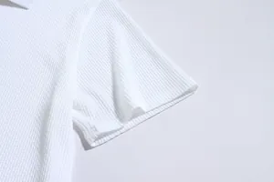 Close-up macro view of the white seersucker textured fabric on men's slim fit polo sleeve